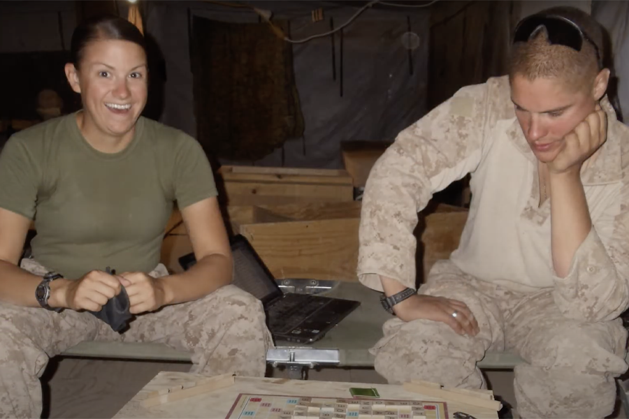 Kim Neville plays a board game with a fellow soldier.